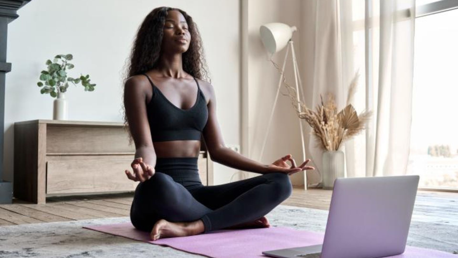 a black woman meditating using her computer